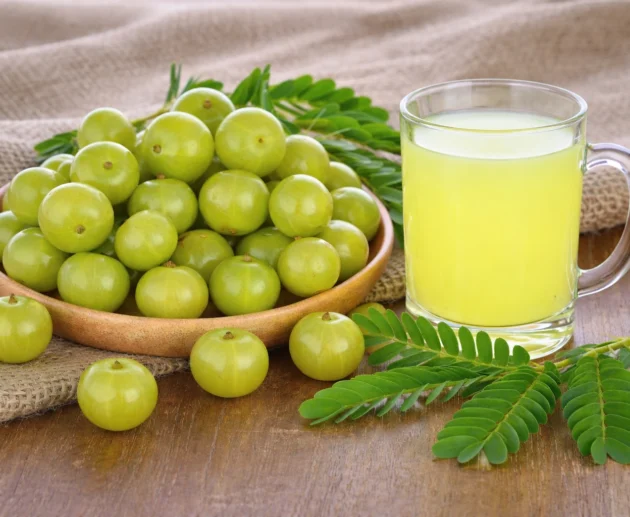 Fresh amla fruits and a glass of amla juice showing natural health benefits and nutrients.