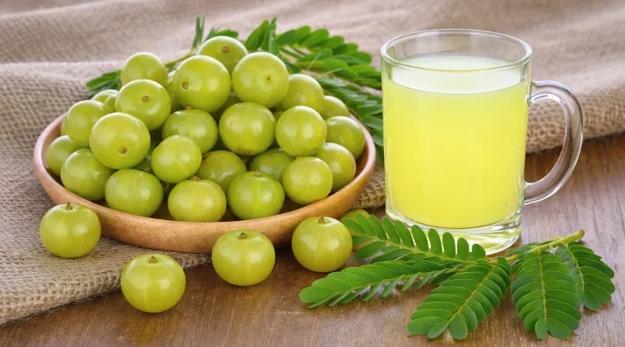 Fresh amla fruits and a glass of amla juice showing natural health benefits and nutrients.