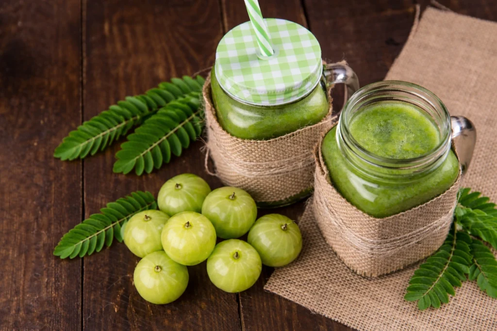 Fresh amla fruits and jars of amla juice showing natural amla juice benefits and traditional health value.